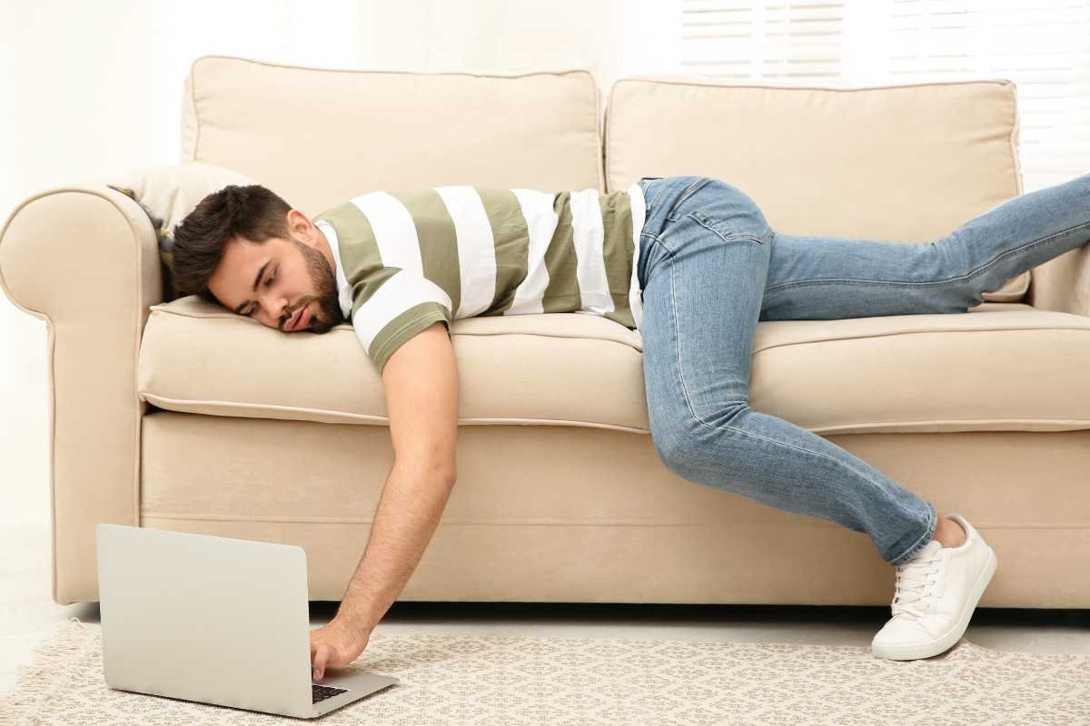 homem deitando no sofá procrastinando